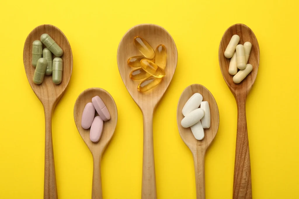 Different vitamin pills in spoons